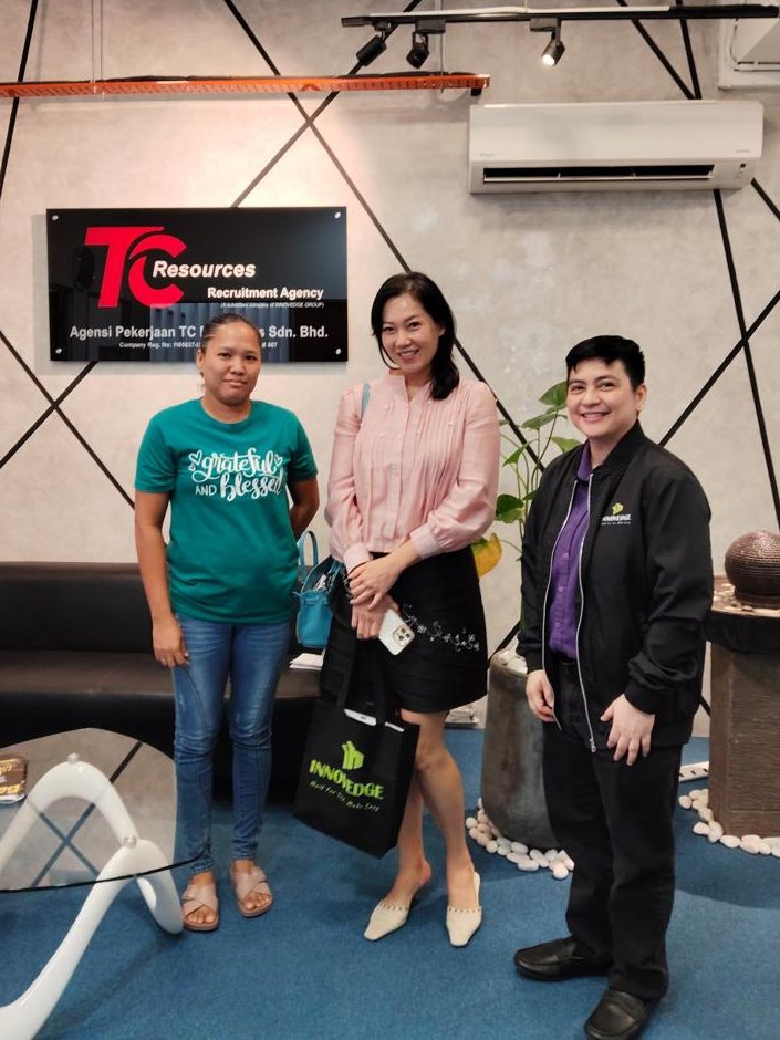 An employer standing with her new helper and a TC Resources consultant at the agency office